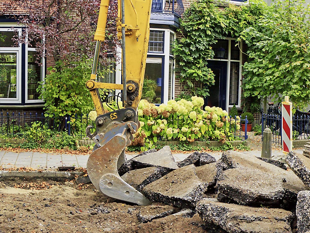 Bild eines Baggers bei der Arbeit vor einem Wohnhaus