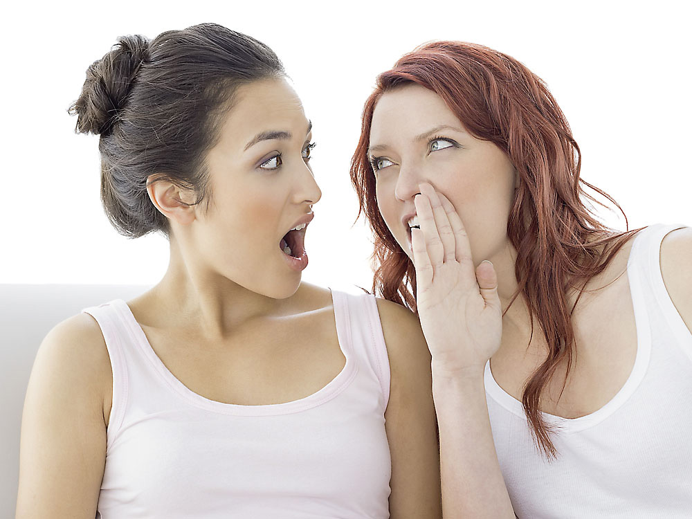 psssst - Frau flüstert einer anderen Frau etwas zu